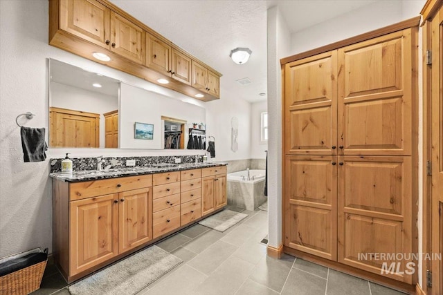 3415 Marble Front Rd, Caldwell, ID 83605 - bathroom featuring a garden tub, a closet, tile patterned floors, double vanity, and recessed lighting