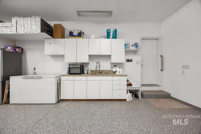 3415 Marble Front Rd, Caldwell, ID 83605 - kitchen featuring a sink, white cabinets, freestanding refrigerator, and light countertops