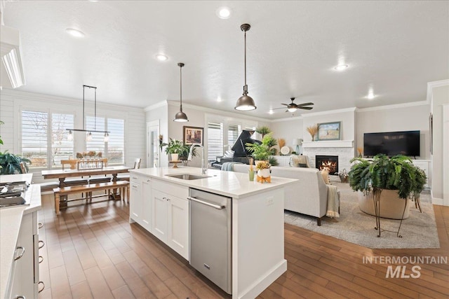4071 S Twilight Rise Ave, Meridian, ID 83642 - kitchen with appliances with stainless steel finishes, ceiling fan, a warm lit fireplace, ornamental molding, and light countertops