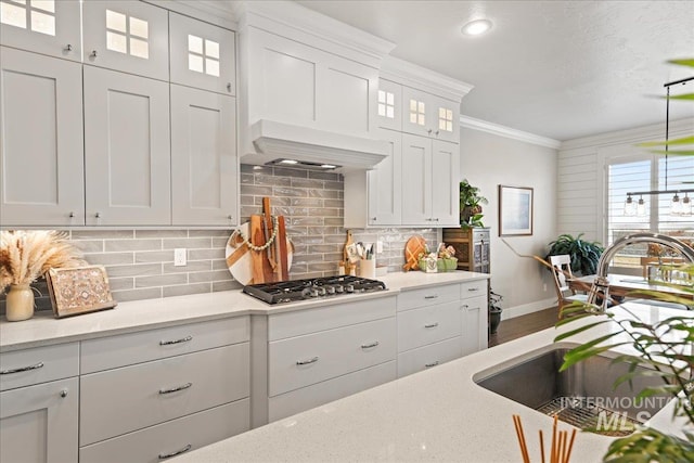 4071 S Twilight Rise Ave, Meridian, ID 83642 - kitchen featuring stainless steel gas stovetop, white cabinets, glass insert cabinets, crown molding, and backsplash