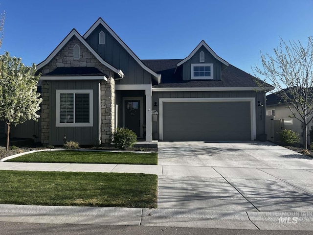 11703 W Amsonia, Star, ID 83669 - view of front of house with board and batten siding, an attached garage, concrete driveway, and stone siding