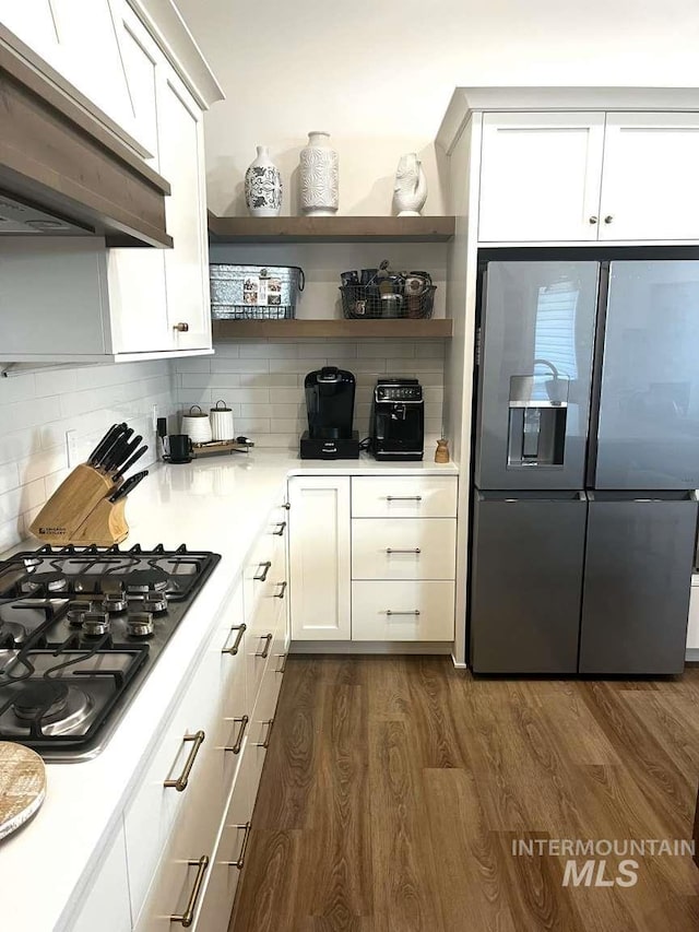 11703 W Amsonia, Star, ID 83669 - kitchen with appliances with stainless steel finishes, range hood, dark wood-type flooring, tasteful backsplash, and open shelves