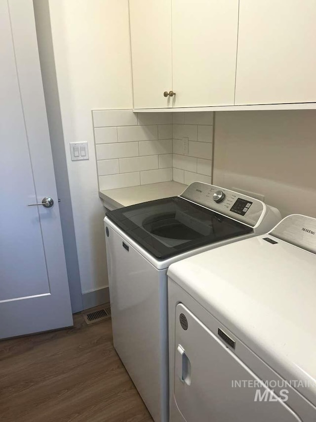 11703 W Amsonia, Star, ID 83669 - laundry room featuring independent washer and dryer, cabinet space, and wood finished floors