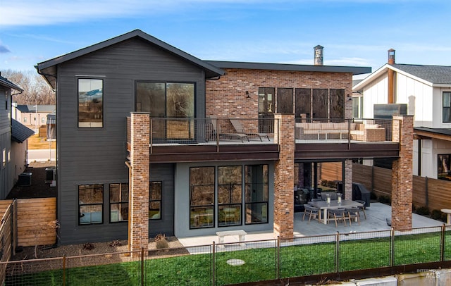 rear view of property with a balcony, a patio, and central AC