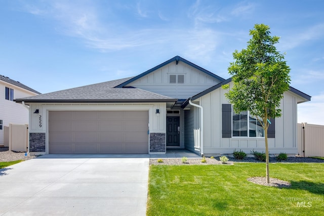 view of front of home featuring a garage, a shingled roof, driveway, board and batten siding, and a front yard