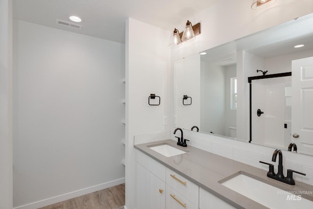 full bathroom with toilet, visible vents, a sink, and wood finished floors