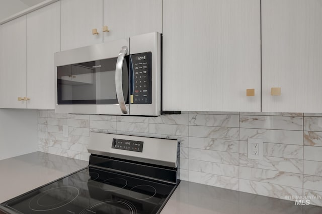 kitchen with appliances with stainless steel finishes, white cabinets, and light countertops