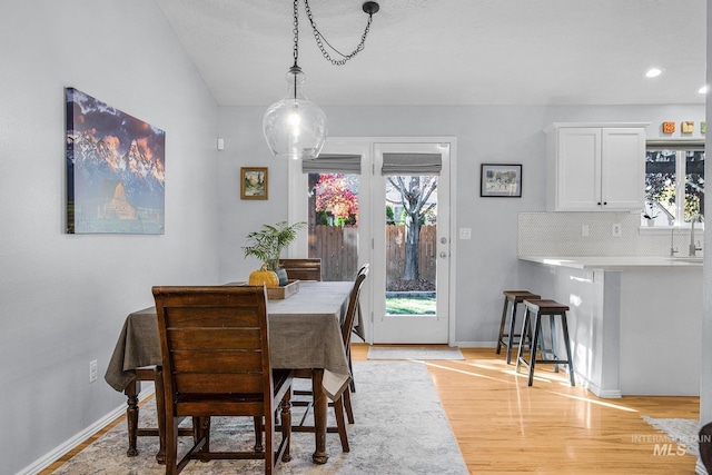 dining space with sink and light wood-type flooring