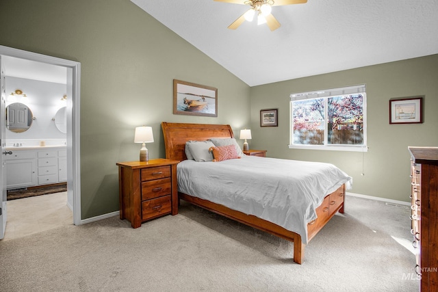 carpeted bedroom with connected bathroom, vaulted ceiling, and ceiling fan