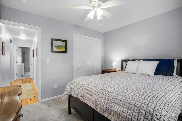 bedroom with ceiling fan, light colored carpet, and a closet