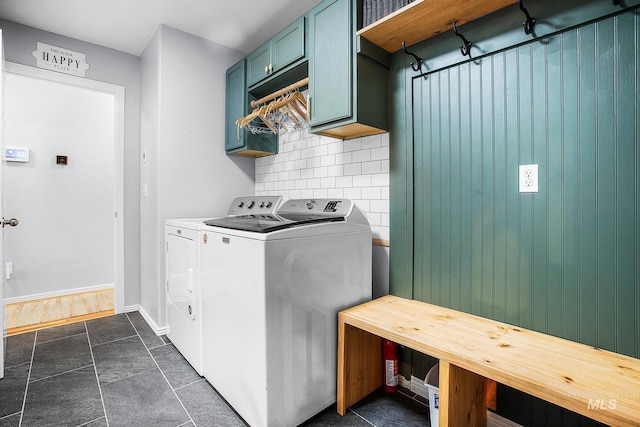 clothes washing area featuring cabinets and independent washer and dryer