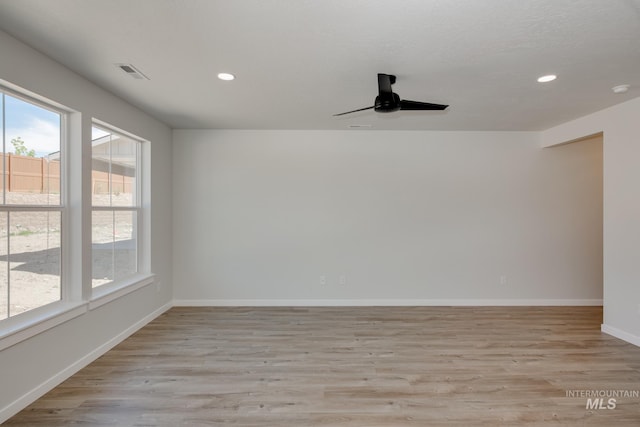 spare room with recessed lighting, visible vents, light wood-style flooring, and baseboards