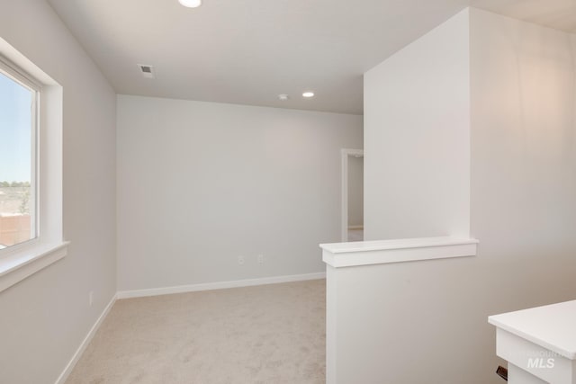 unfurnished room featuring light carpet, recessed lighting, and baseboards