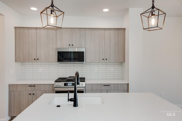 kitchen featuring hanging light fixtures, stainless steel appliances, light countertops, and light brown cabinetry