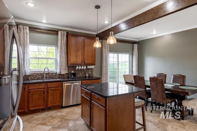 1027 Larkspur, Moscow, ID 83843 - kitchen featuring stainless steel appliances, a sink, a kitchen breakfast bar, brown cabinetry, and crown molding