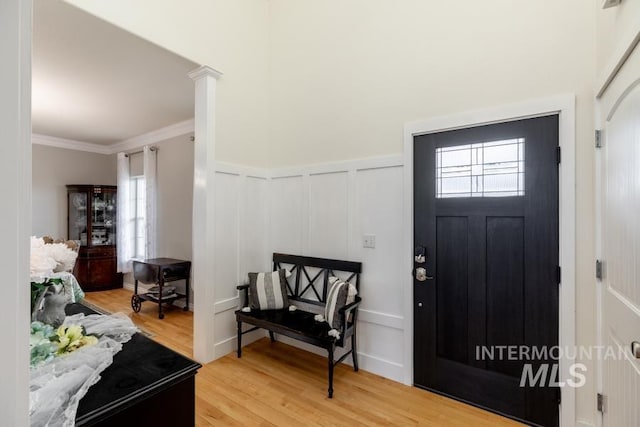 1027 Larkspur, Moscow, ID 83843 - entrance foyer featuring a decorative wall, healthy amount of natural light, light wood finished floors, crown molding, and wainscoting
