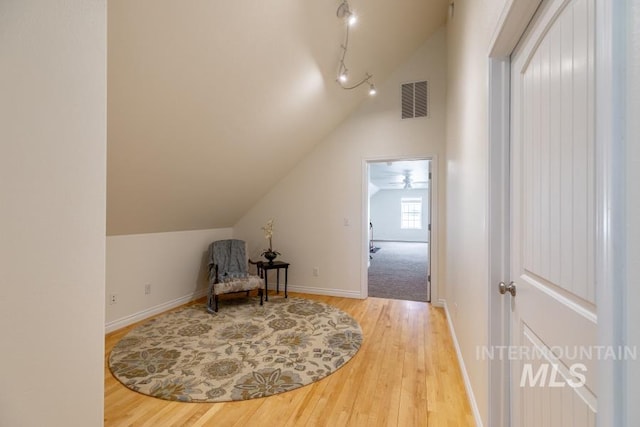 1027 Larkspur, Moscow, ID 83843 - sitting room featuring vaulted ceiling, hardwood / wood-style flooring, baseboards, and rail lighting