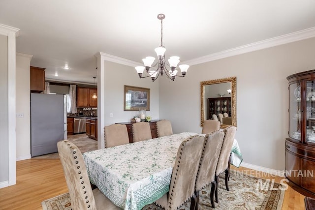 1027 Larkspur, Moscow, ID 83843 - dining room featuring a chandelier, crown molding, light wood-style flooring, and baseboards