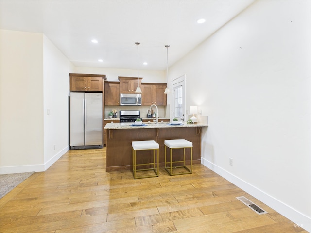 9389 W Wildbranch, Star, ID 83669 - kitchen featuring stainless steel appliances, a peninsula, recessed lighting, baseboards, and light wood finished floors