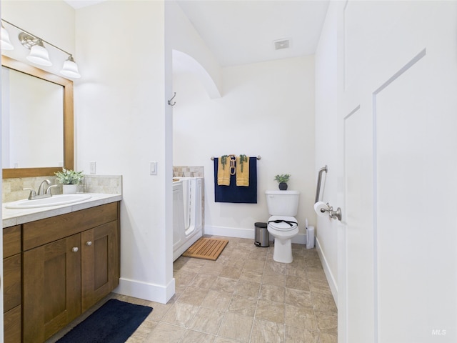 9389 W Wildbranch, Star, ID 83669 - bathroom with vanity, baseboards, toilet, and tasteful backsplash
