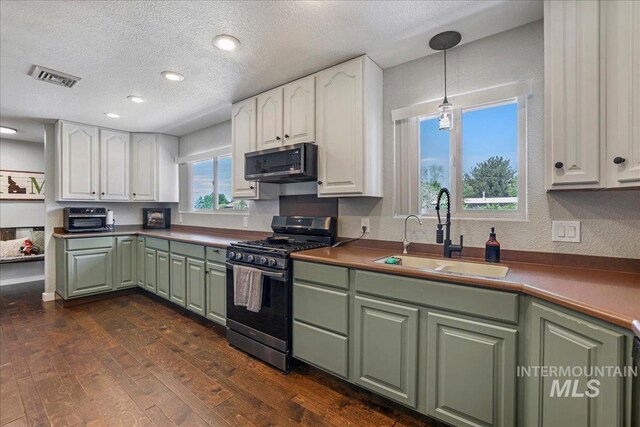 1011 Filer Ave W, Twin Falls, ID 83301 - kitchen with stainless steel appliances, green cabinetry, a sink, white cabinetry, and dark wood-type flooring