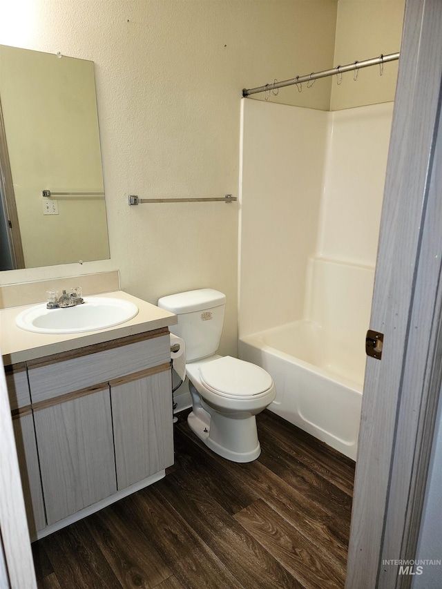 full bathroom featuring vanity, toilet, wood finished floors, and shower / washtub combination