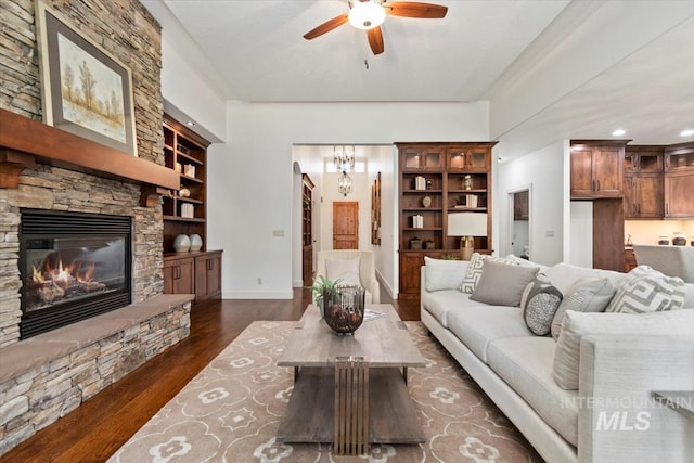 6964 N Moon Drummer Way, Meridian, ID 83646 - living area featuring dark wood finished floors, built in shelves, a ceiling fan, a fireplace, and baseboards