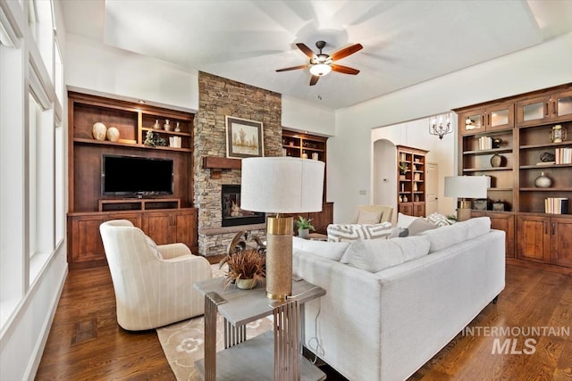 6964 N Moon Drummer Way, Meridian, ID 83646 - living area featuring a ceiling fan, a fireplace, dark wood-type flooring, built in features, and a chandelier