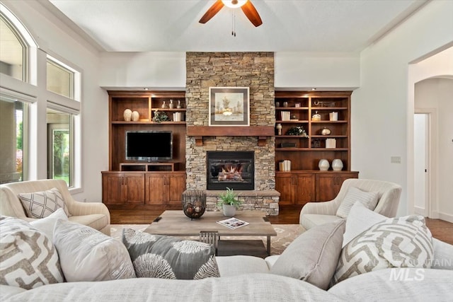 6964 N Moon Drummer Way, Meridian, ID 83646 - living area with ceiling fan, wood finished floors, a stone fireplace, and arched walkways
