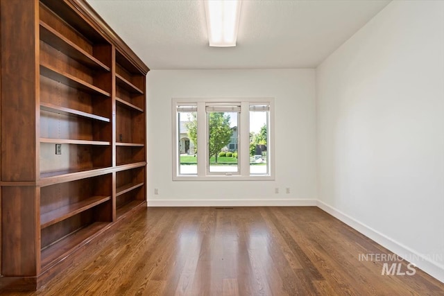 6964 N Moon Drummer Way, Meridian, ID 83646 - unfurnished room with baseboards and dark wood-type flooring