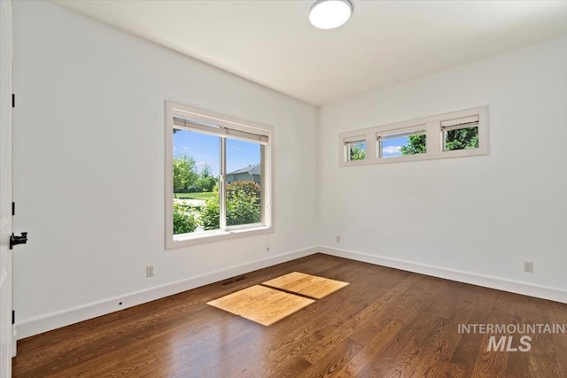 6964 N Moon Drummer Way, Meridian, ID 83646 - unfurnished room featuring baseboards and dark wood-style floors