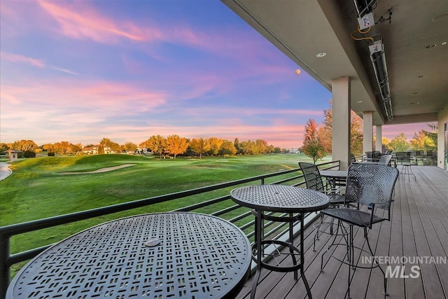 6964 N Moon Drummer Way, Meridian, ID 83646 - deck at dusk with outdoor dining area, view of golf course, and a yard