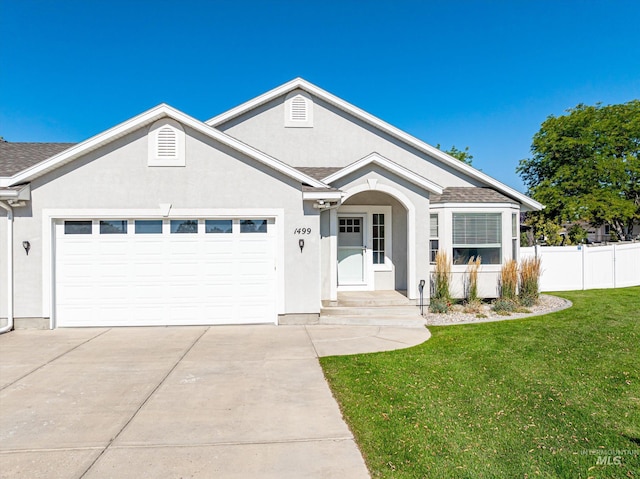 single story home with a garage and a front lawn