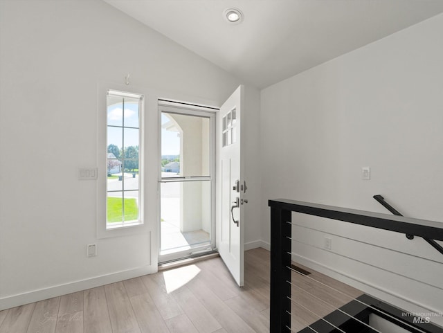 foyer entrance featuring vaulted ceiling and light hardwood / wood-style floors