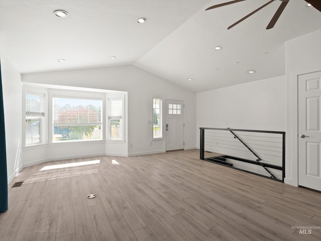 unfurnished living room with vaulted ceiling and light wood-type flooring