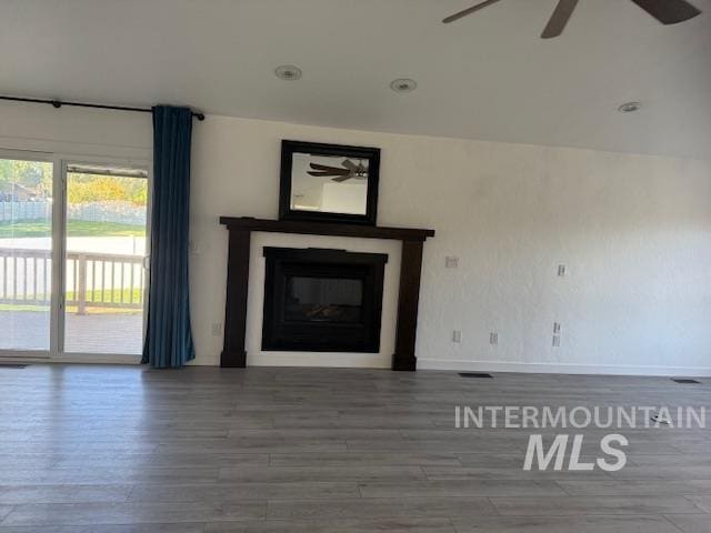 unfurnished living room with ceiling fan and wood-type flooring