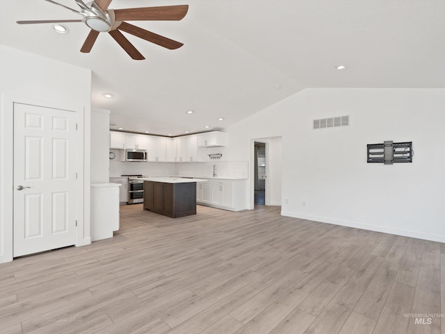 unfurnished living room featuring lofted ceiling, sink, ceiling fan, and light hardwood / wood-style flooring