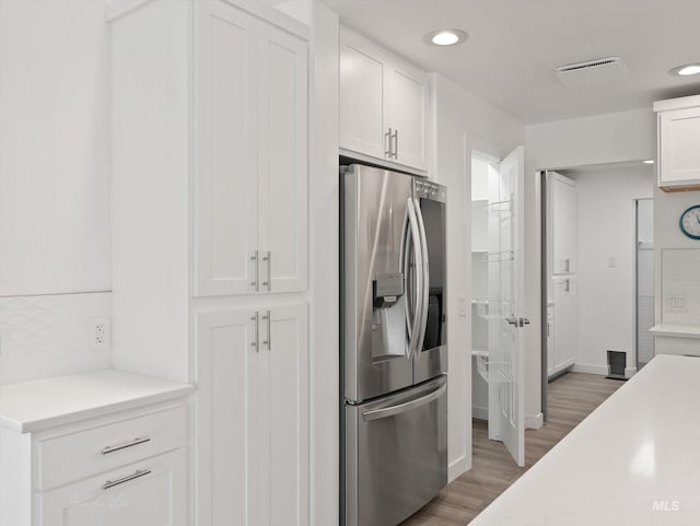 kitchen featuring white cabinetry, dark hardwood / wood-style flooring, and stainless steel fridge with ice dispenser