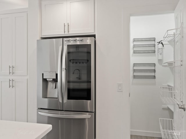 kitchen featuring white cabinetry and stainless steel fridge with ice dispenser