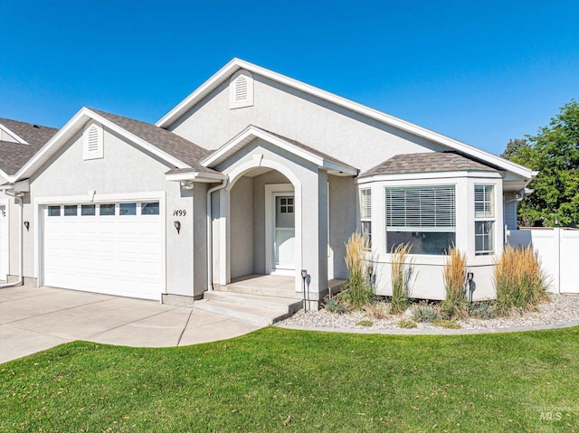 ranch-style home with a garage and a front lawn