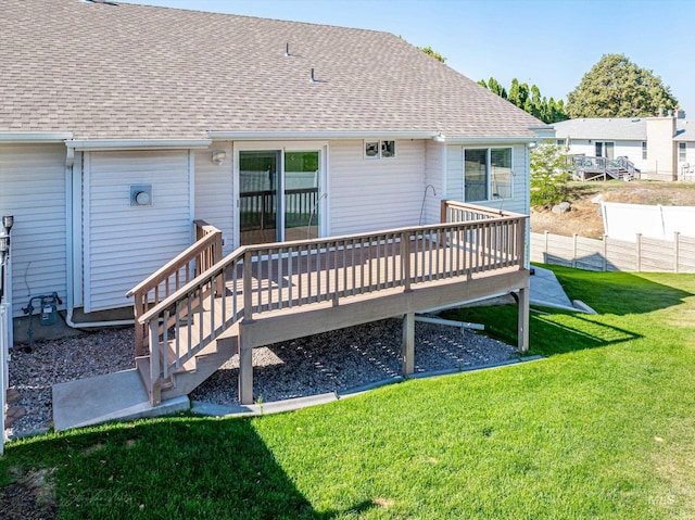 rear view of house featuring a wooden deck and a lawn