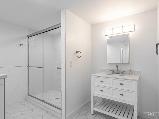 bathroom featuring tile patterned flooring, vanity, and walk in shower