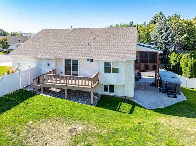 rear view of house with a sunroom, a deck, a patio, and a lawn