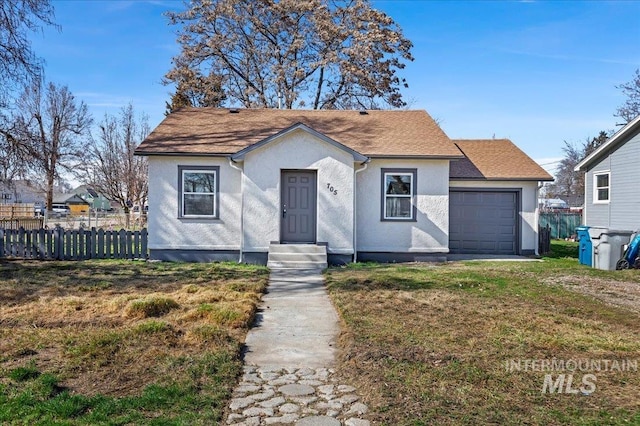 bungalow-style home featuring a front lawn, fence, entry steps, stucco siding, and a garage