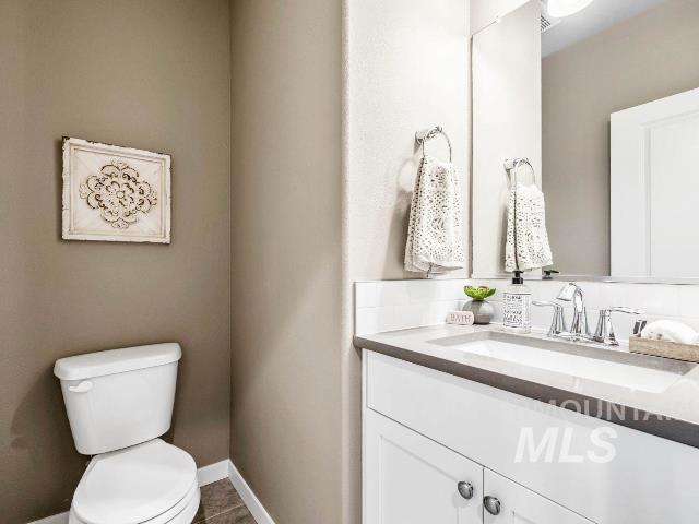 bathroom with tile patterned flooring, vanity, and toilet