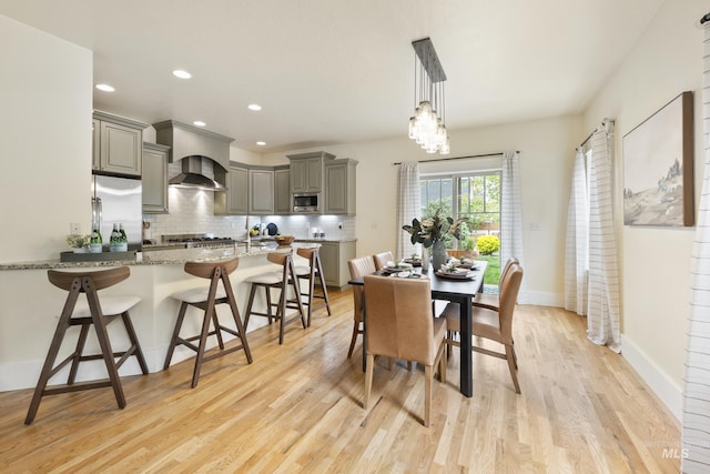 dining space with baseboards, recessed lighting, and light wood-style flooring
