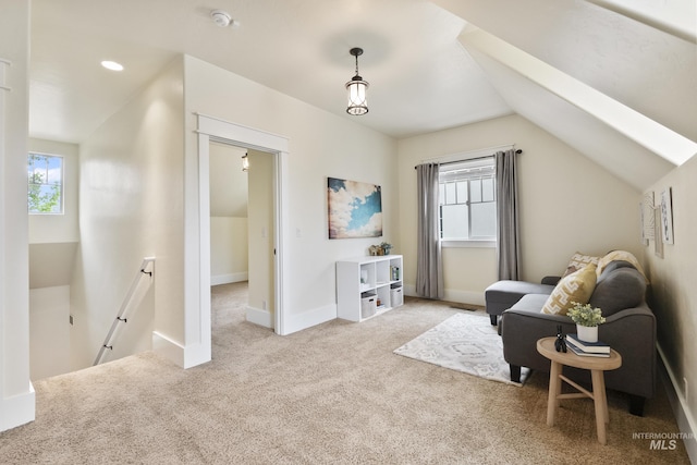 living area with light colored carpet, baseboards, an upstairs landing, and vaulted ceiling