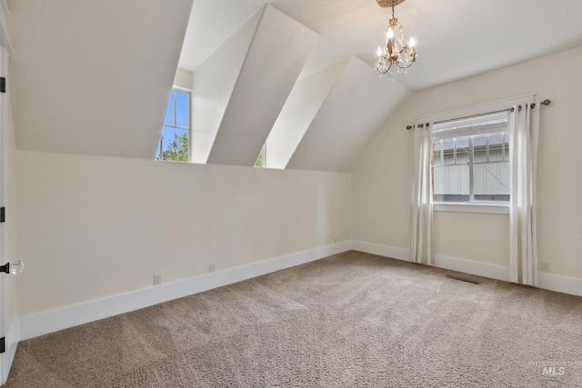 additional living space featuring carpet flooring, baseboards, vaulted ceiling, and a healthy amount of sunlight
