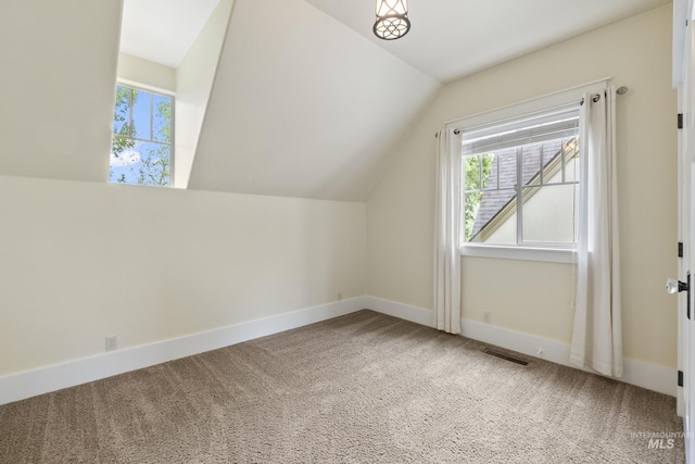 additional living space with plenty of natural light, carpet flooring, visible vents, and lofted ceiling