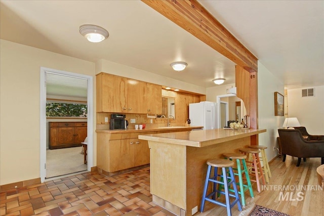 424 N Mobley Dr, Boise, ID 83712 - kitchen with freestanding refrigerator, light countertops, a kitchen breakfast bar, a sink, and a peninsula